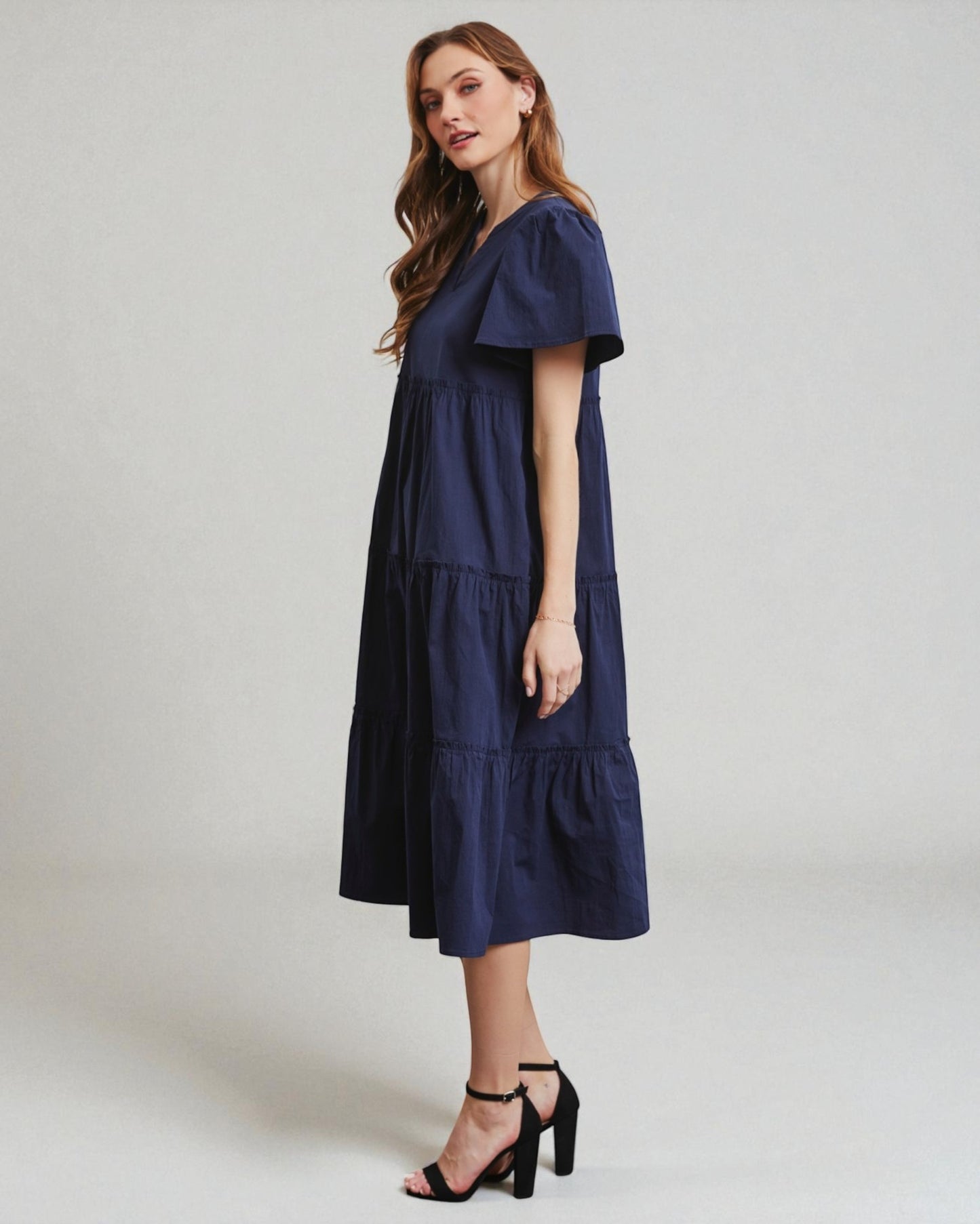 Woman wearing a navy blue dress against a white background