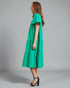 Woman wearing a green dress against a gray background