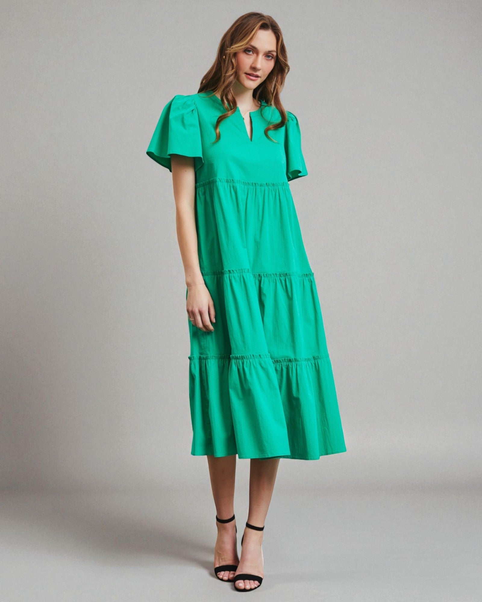 Woman wearing a green dress against a gray background