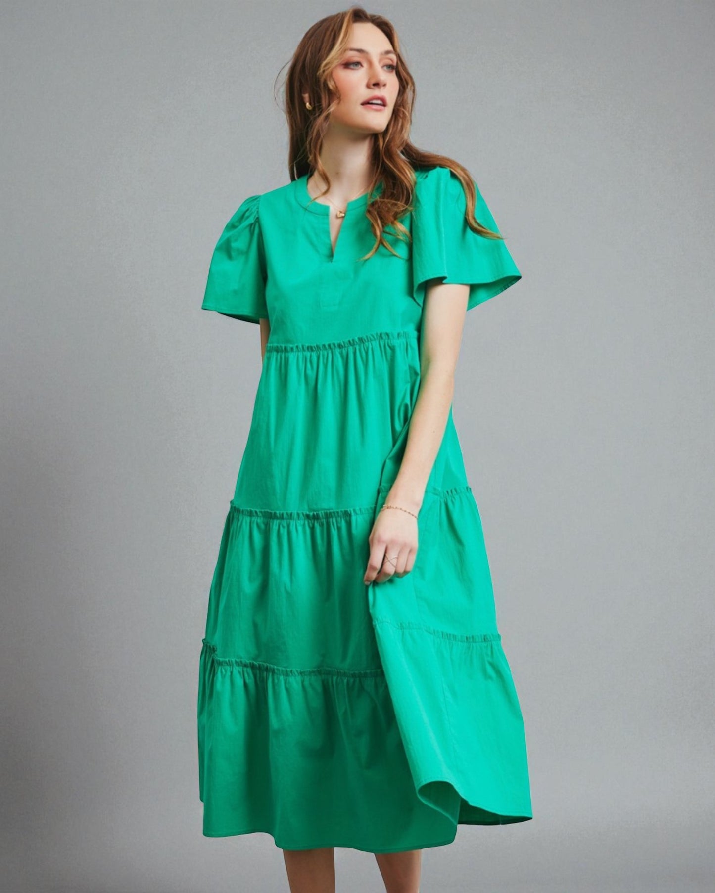 Woman wearing a green dress against a gray background