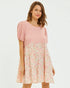 Woman wearing a pink dress with floral skirt on a white background