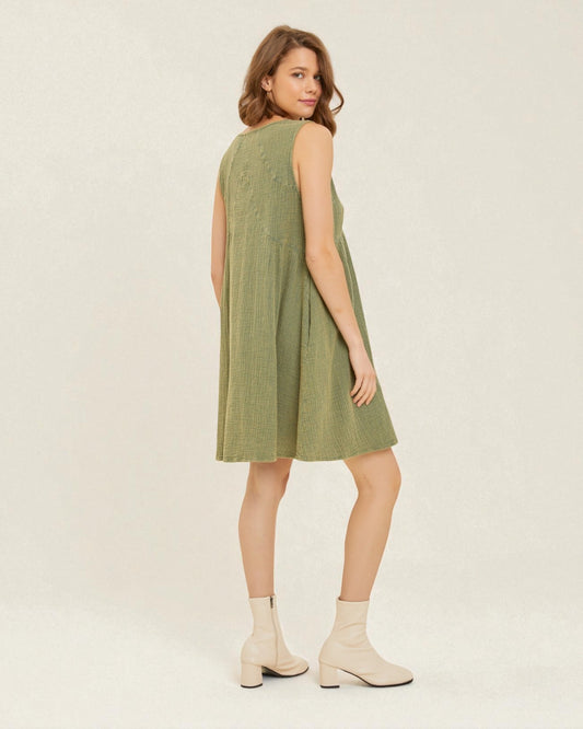 Woman wearing a green dress on a plain background