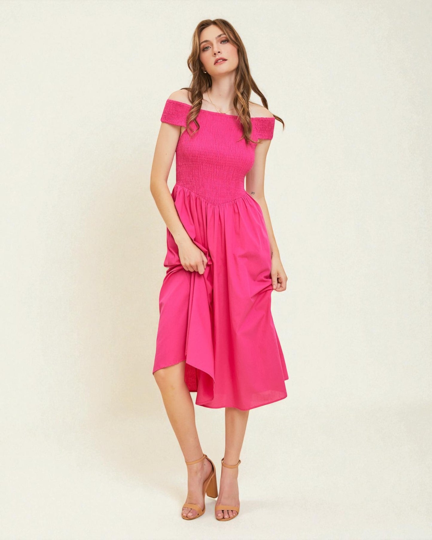 Woman wearing a pink off-shoulder dress on a white background