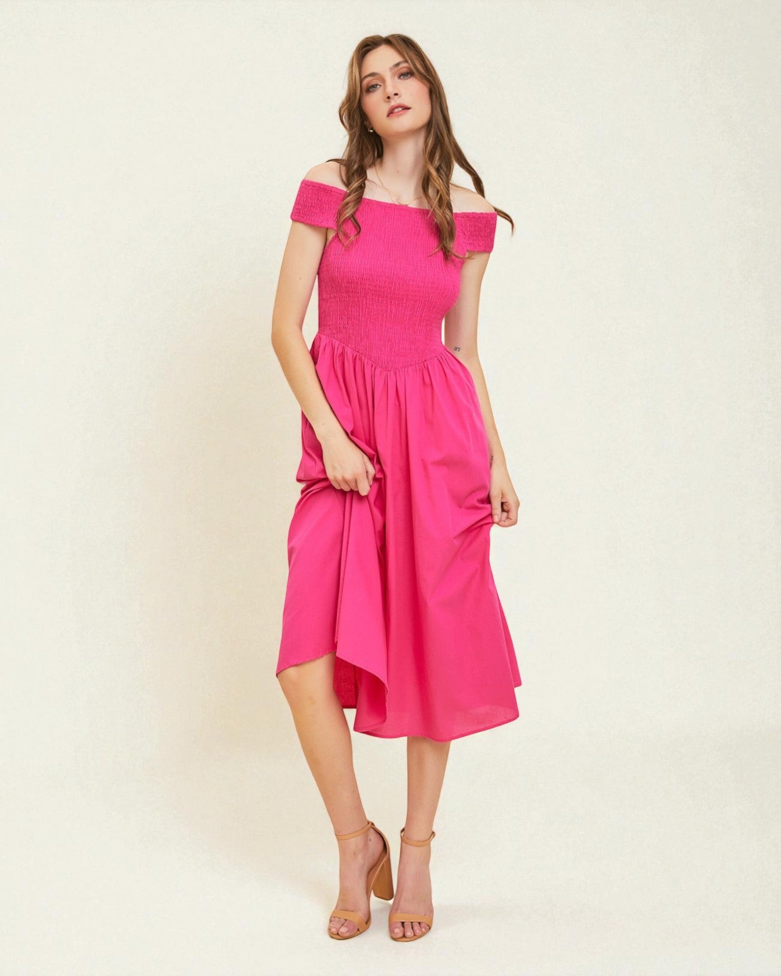 Woman wearing a pink off-shoulder dress on a white background