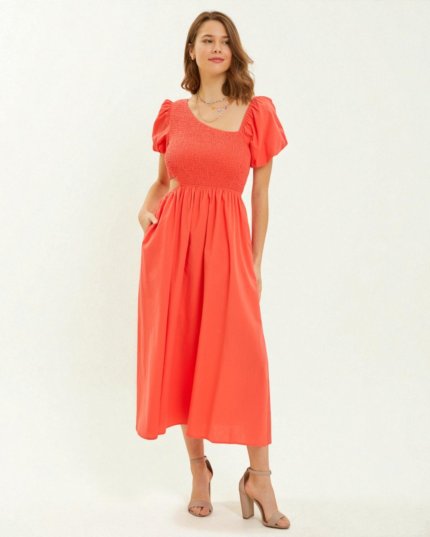 Woman wearing a coral dress on a white background