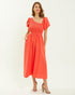 Woman wearing a coral dress on a white background