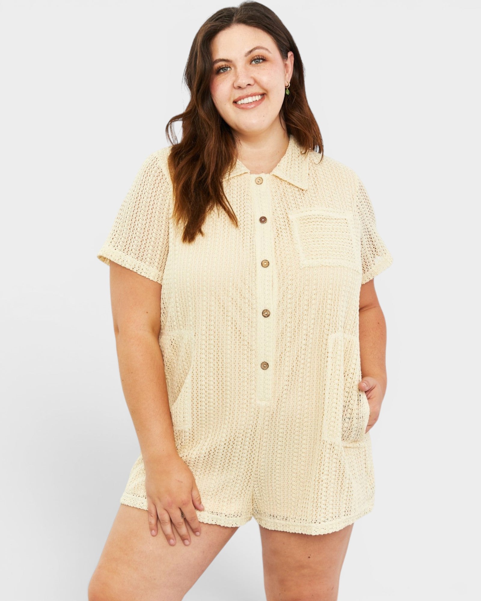Woman wearing a beige textured romper on a white background