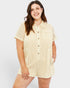 Woman wearing a beige textured romper on a white background