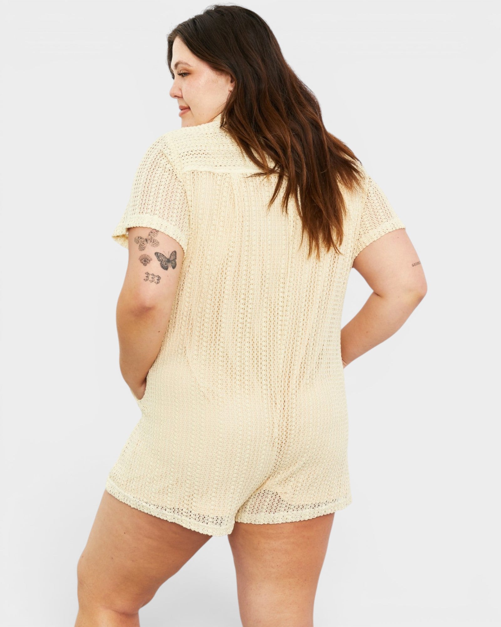 Woman wearing a beige textured romper on a white background