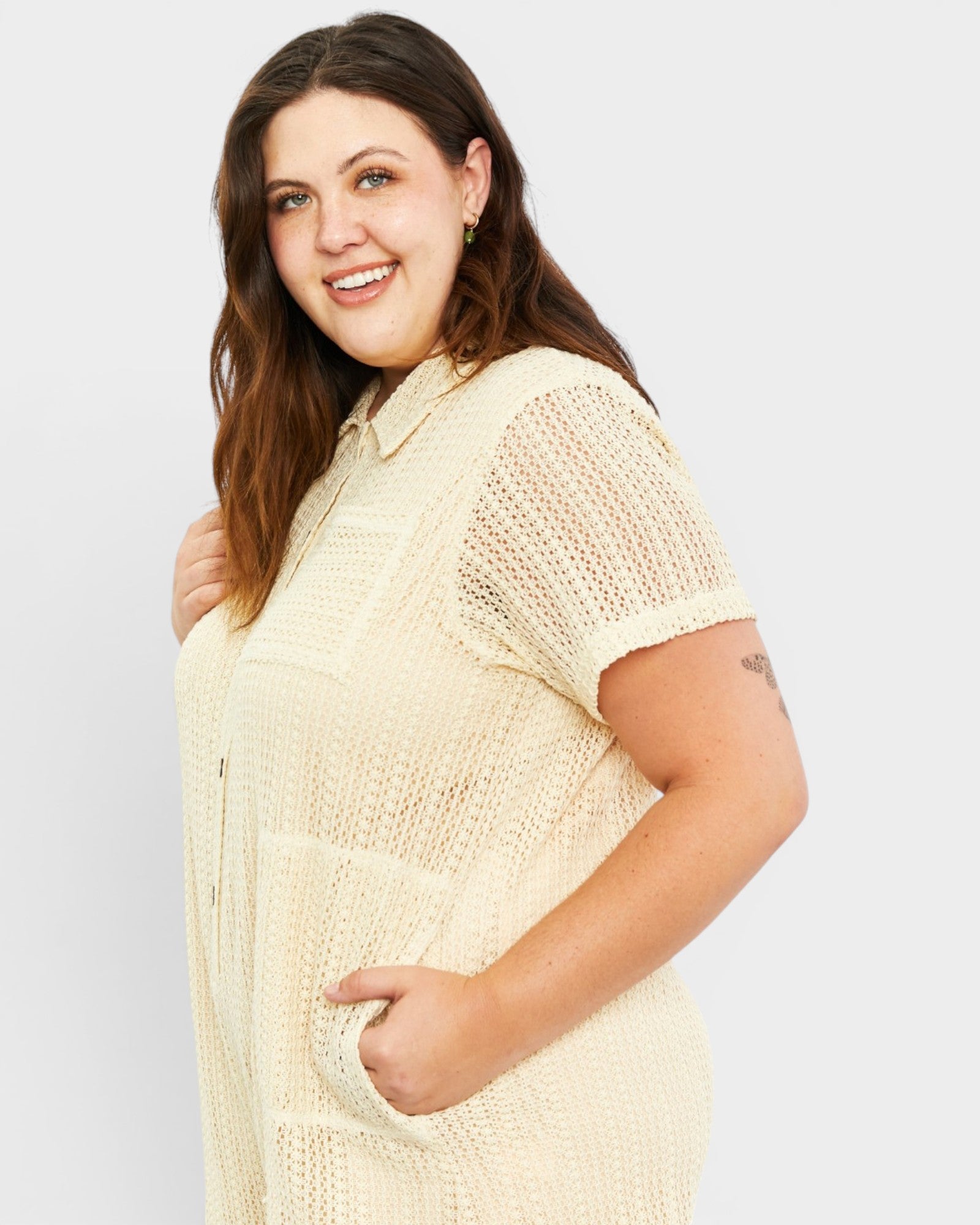 Woman wearing a beige textured romper on a white background