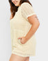 Woman wearing a beige textured romper on a white background
