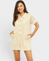 Woman wearing a beige textured romper on a white background