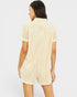 Woman wearing a textured beige romper on a white background