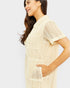 Woman wearing a beige textured romper on a white background