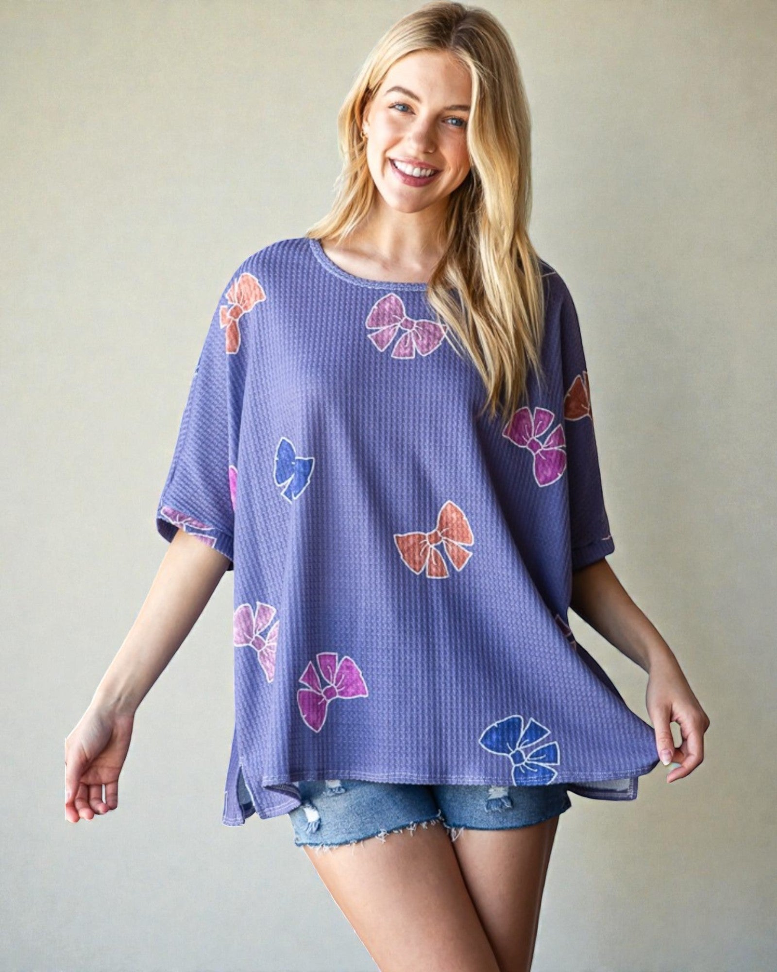 Woman wearing a purple floral patterned top against a plain background