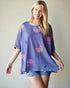 Woman wearing a purple floral patterned top against a plain background