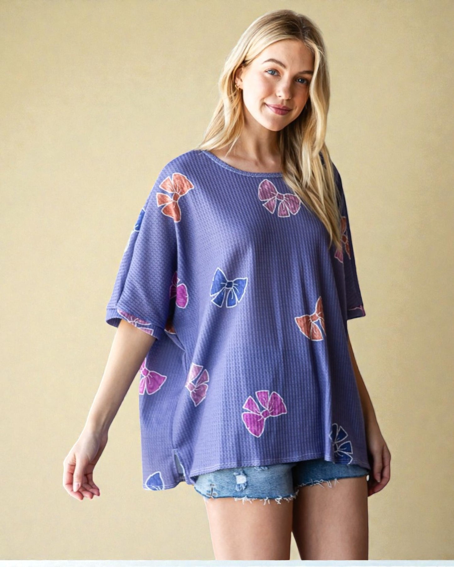 Woman wearing a purple top with butterfly patterns on a beige background