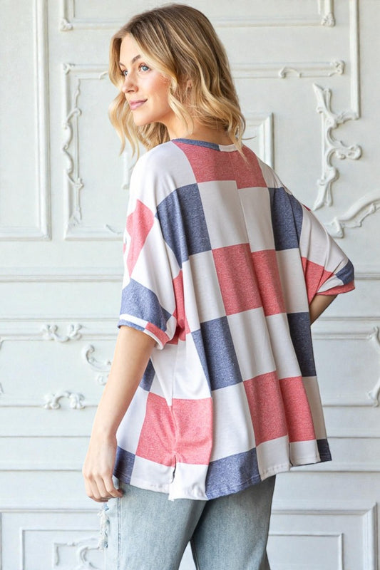 Woman wearing a colorful striped shirt against a white decorative wall.