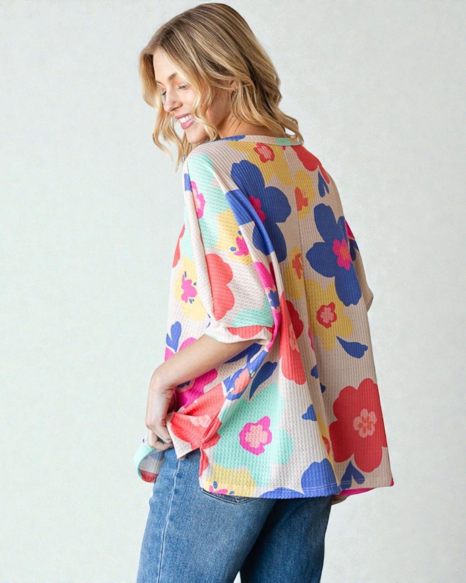 Woman wearing a colorful floral kimono against a white background