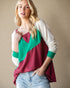 Woman wearing a colorful sweater with a beige background