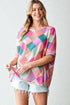 Woman wearing a colorful checkered top with a plain background