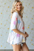 Woman wearing a white kimono with colorful star patterns against a light background