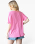A woman shown from the back wearing a bright pink short-sleeve t-shirt and denim shorts against a plain white background.