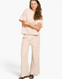 Beach Rose Co. sand beige ribbed two-piece set with a round neck tee and wide-leg pants on a smiling woman