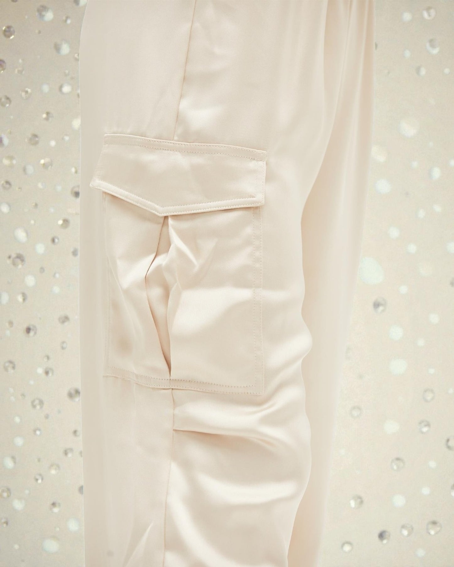 Close-up of a light pink shirt with a pocket on a textured white background