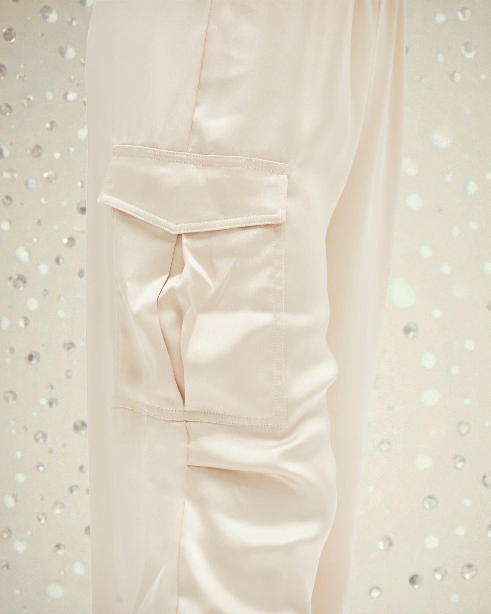 Close-up of a light pink shirt with a pocket on a textured white background