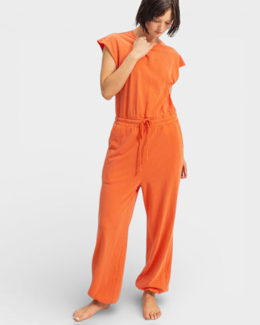 Woman wearing an orange jumpsuit on a white background