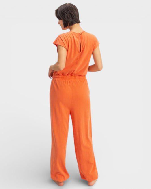 Person wearing an orange jumpsuit on a white background