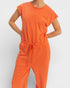Person wearing an orange jumpsuit on a plain background