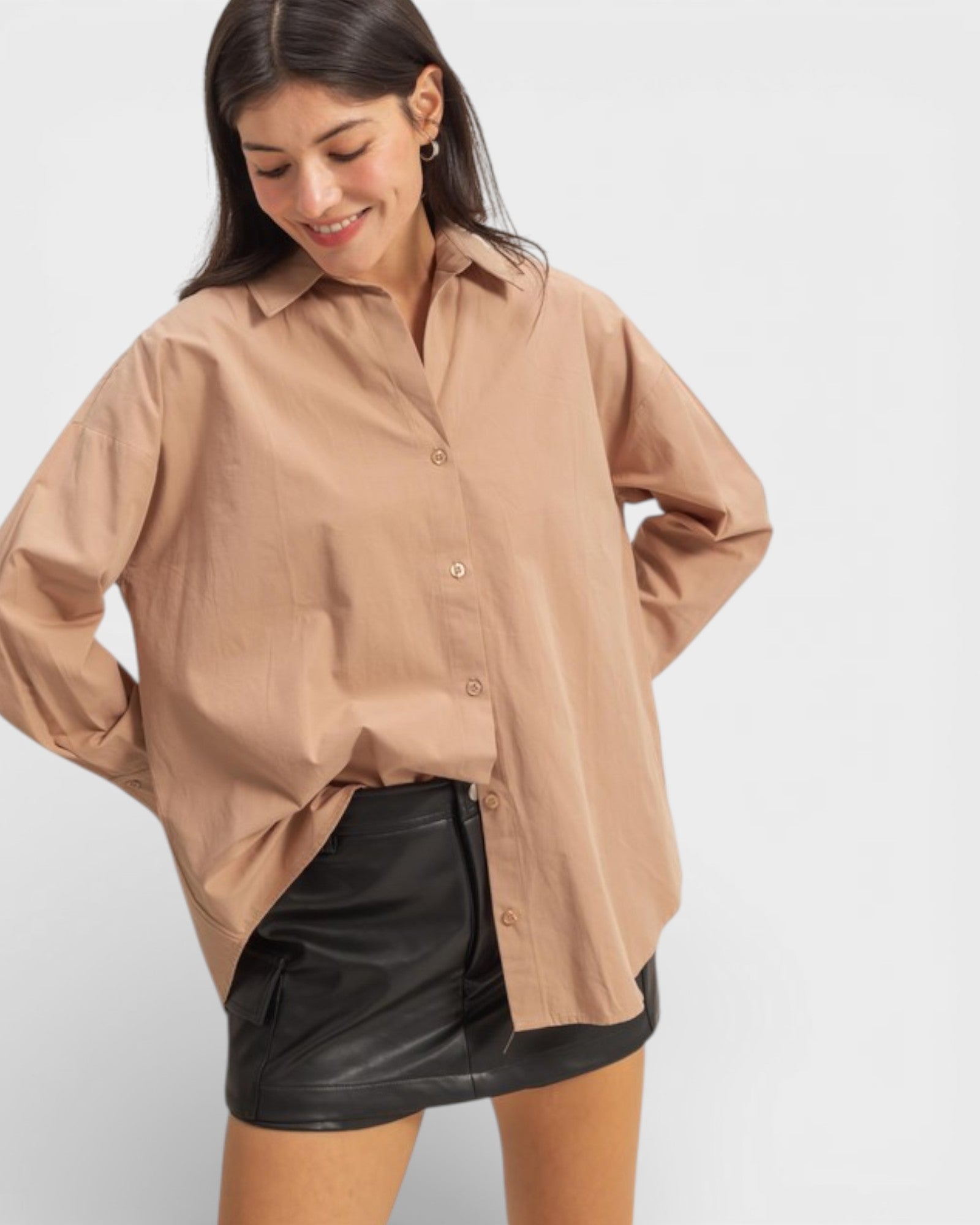 Woman wearing a beige shirt and black leather skirt on a white background