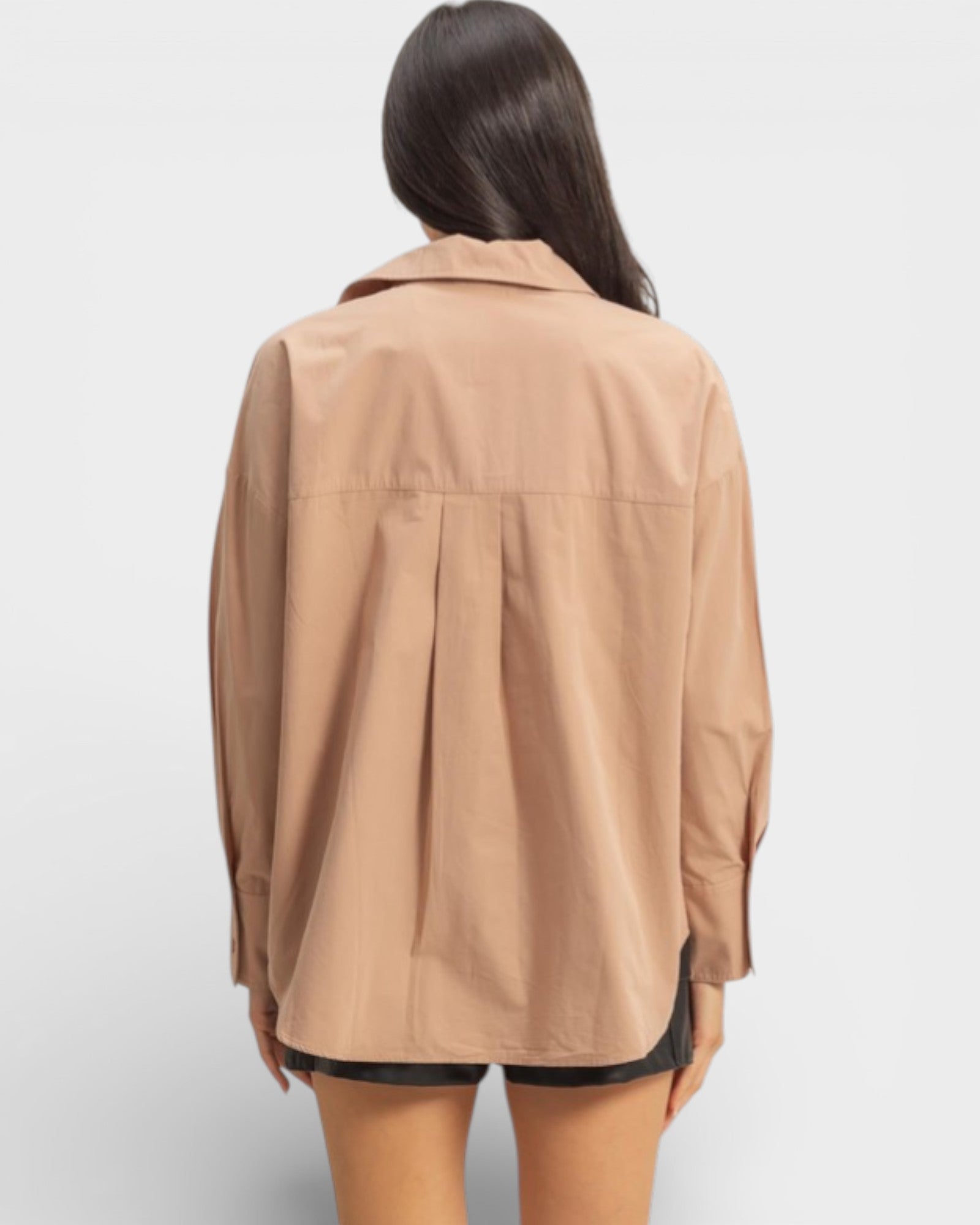 Person wearing a beige jacket on a plain background
