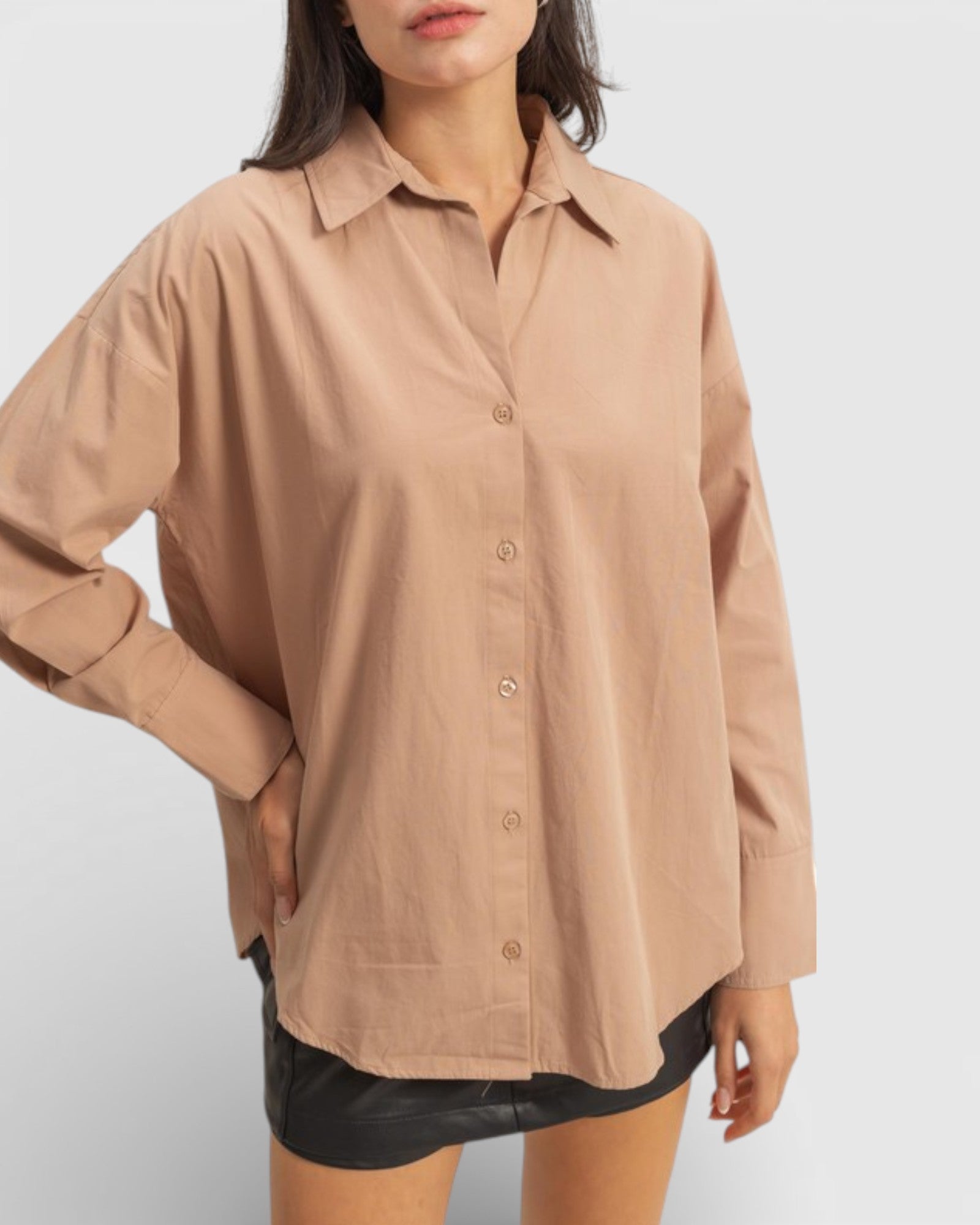 Person wearing a beige button-up shirt on a white background