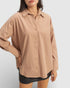 Person wearing a beige button-up shirt on a white background