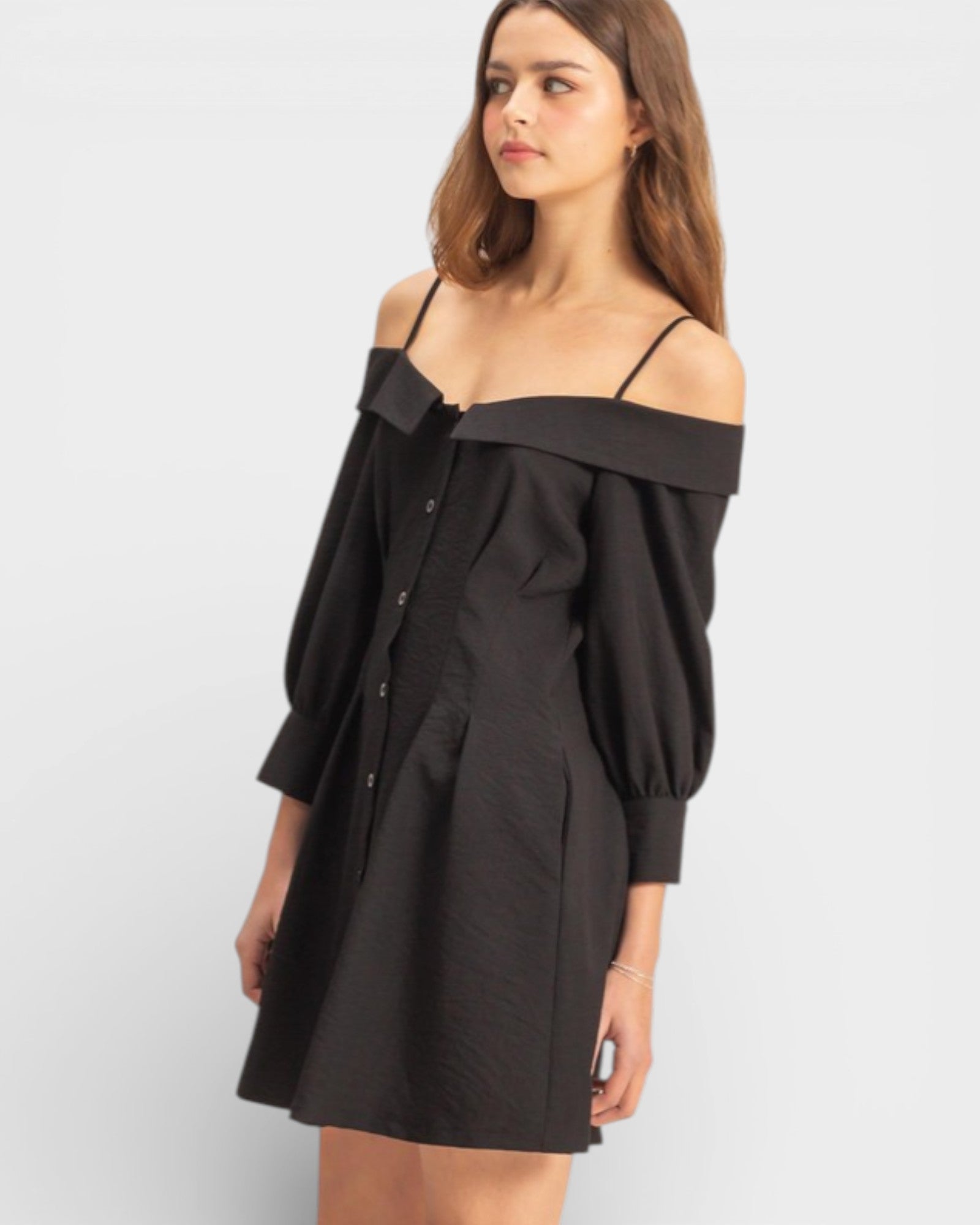 Woman wearing a black off-shoulder dress on a white background