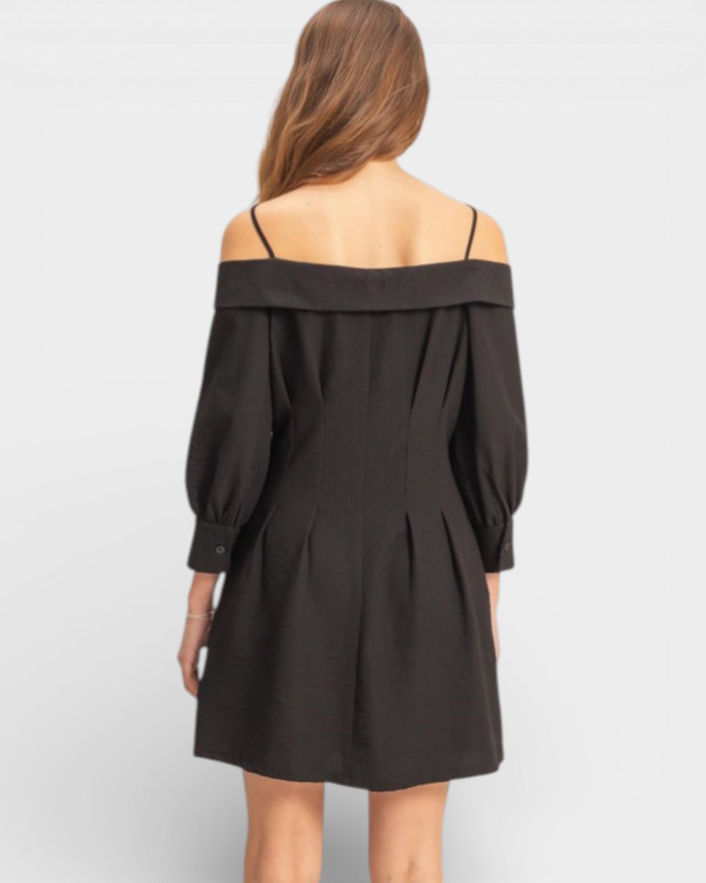 Black off-shoulder dress worn by a person on a white background