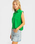 Woman wearing a green sleeveless shirt and denim shorts on a white background