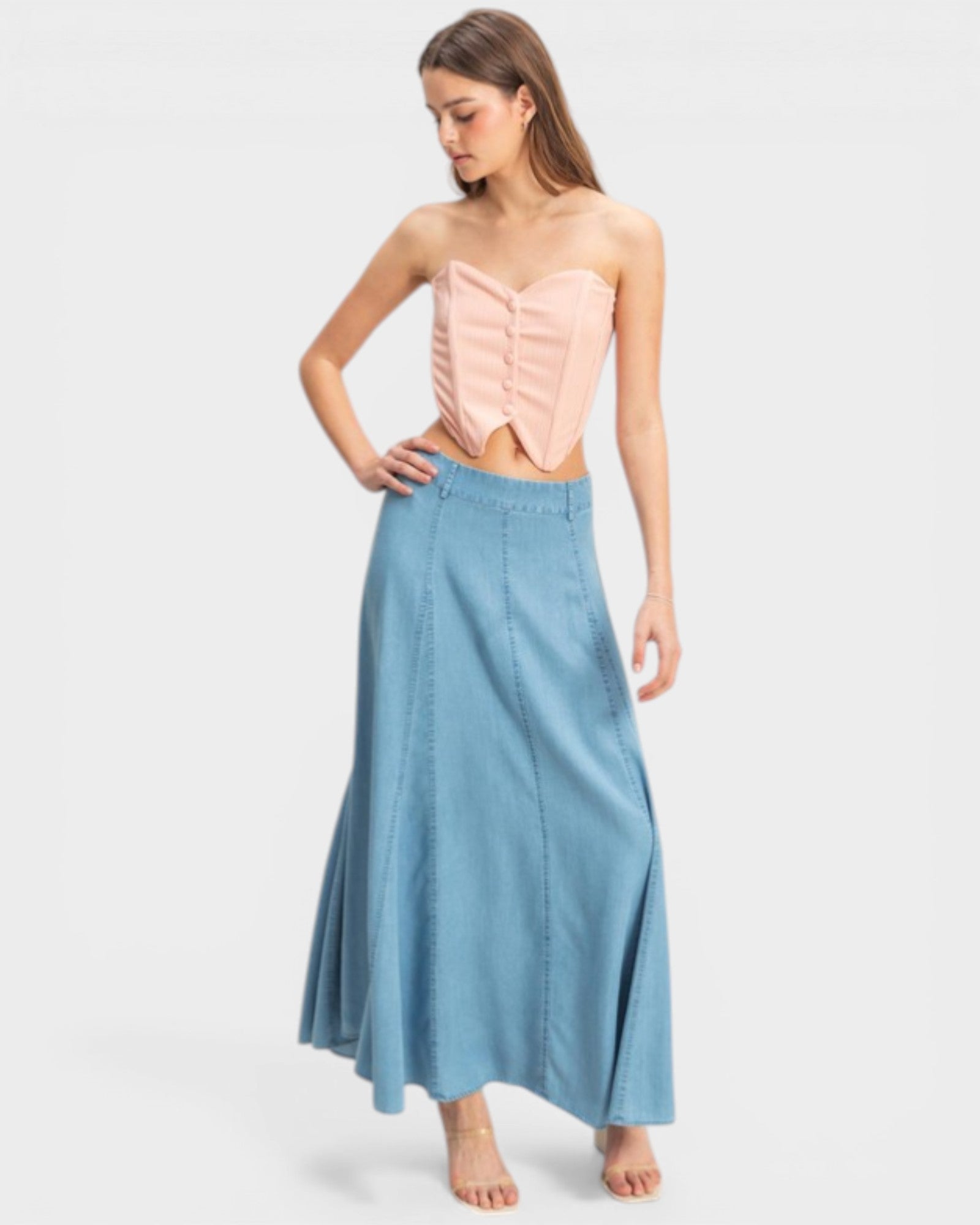 Woman wearing a pink top and blue skirt on a white background