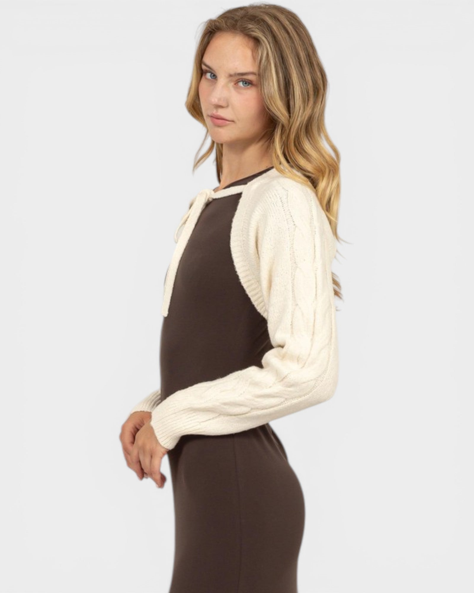 Woman wearing a brown and cream sweater on a white background