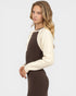 Woman wearing a brown and cream sweater on a white background