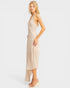 Woman wearing a beige halter neck dress on a white background