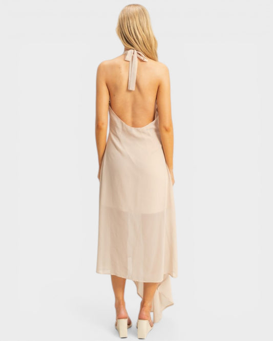 Beige halter neck dress with a tie detail on a white background