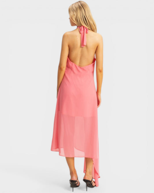 Woman wearing a pink halter neck dress on a white background