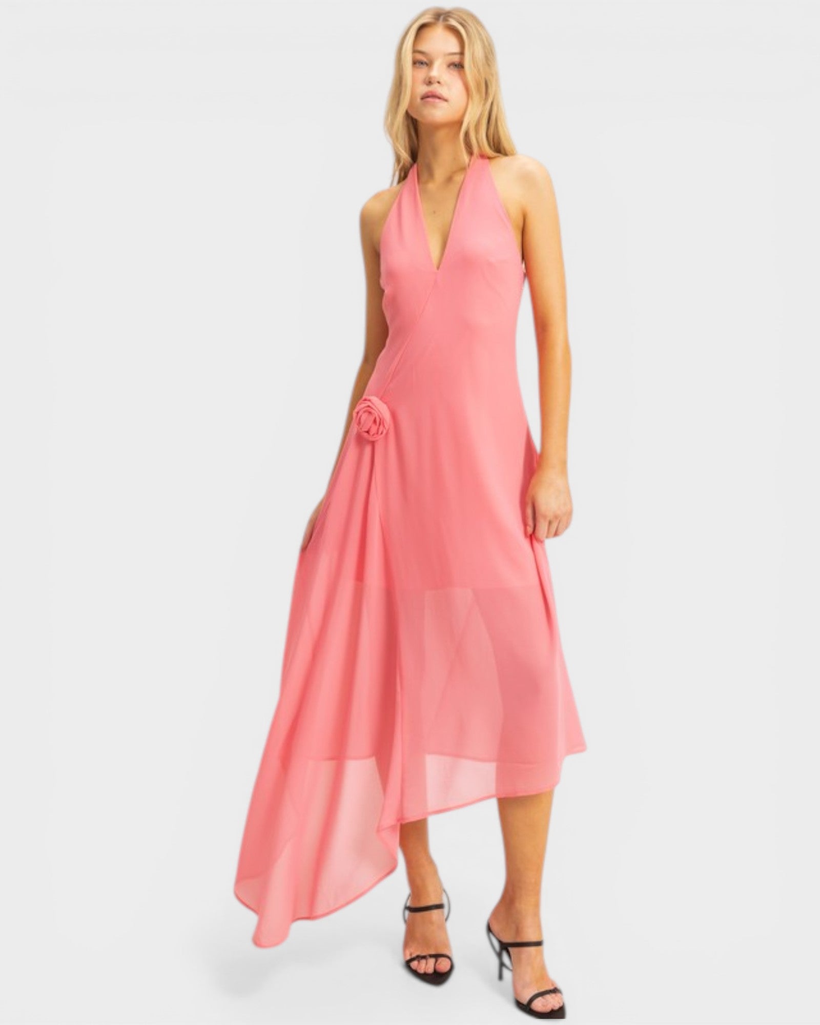 Woman wearing a pink halter neck dress on a white background