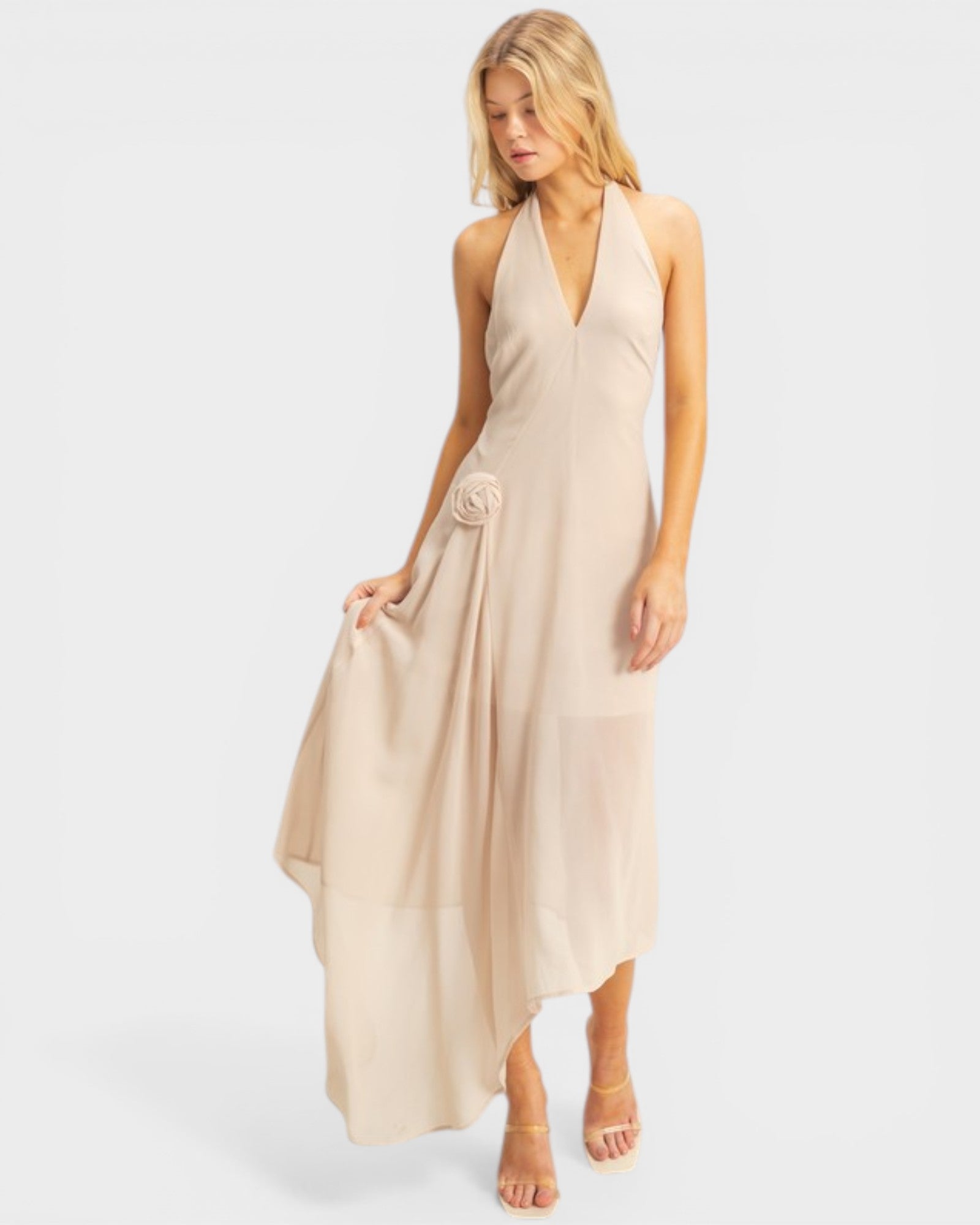 Woman wearing a beige halter neck dress on a white background