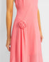 Coral pink dress with a floral detail on a plain background