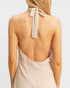 Beige halter neck top with a tie detail on a plain background